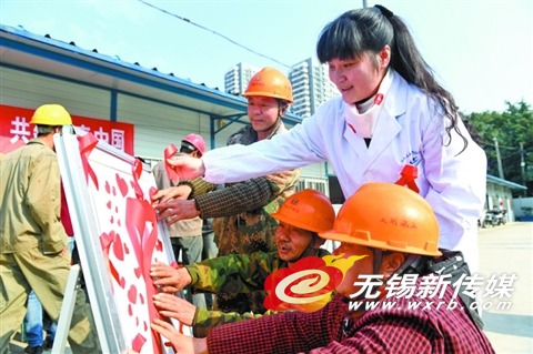 疾控专业人员在建筑工地 与工人们一起粘贴红