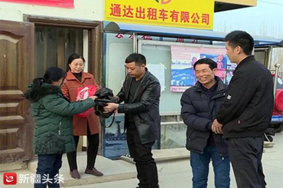 出租车公司负责人将包还给失主。