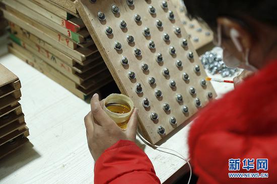 这是微型耳机喇叭生产过程中的分线工序。新华网记者 焦鹏 摄