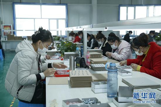 阿图什市阿湖乡就业创业基地女职工正在加工生产微型耳机喇叭。