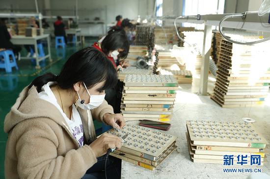 这是阿图什市阿湖乡就业创业基地女职工在进行焊锡工艺操作。新华网记者 焦鹏 摄