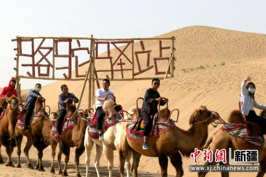 10月1日,游客在沙漠体验骆驼乘骑。汪志鹏摄