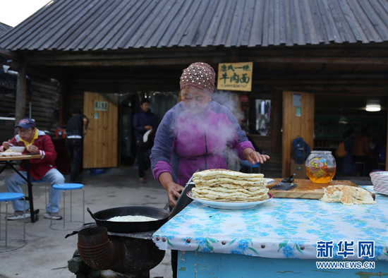 图为当地百姓正在制作早餐。新华网 刘舒 摄