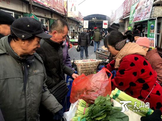12月27日,乌鲁木齐市北园春农贸批发市场里人流如织,商家支起临时摊,随着吆喝声,消费者们正在购买两把5元的毛芹菜和蒜苔。