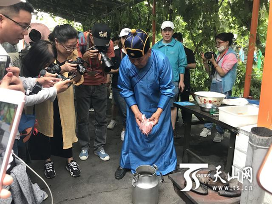 达人们在拍摄精河县当地美食“石头焖肉”。