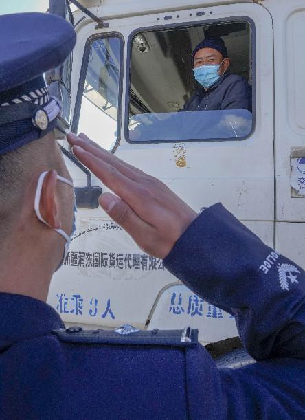 在新疆卡拉苏口岸,卡拉苏出入境边防检查站警官杨开祥向出境车辆驾驶员敬礼(10月16日摄)。