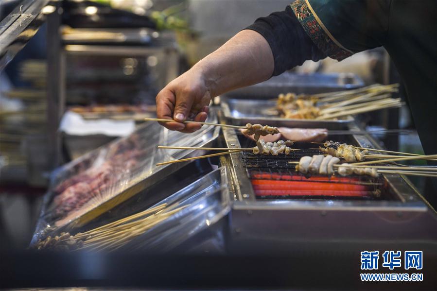 3月16日，在和田夜市环湖店，商贩在制作烤串。新华社记者 赵戈 摄