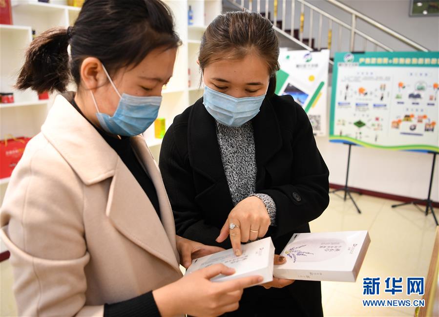 4月18日,在新疆伊犁哈萨克自治州新源县电子商务公共服务中心,创业者哈伊夏·加尔肯(右)向中心另一名工作人员介绍商品。 新华社记者 宋彦桦 摄