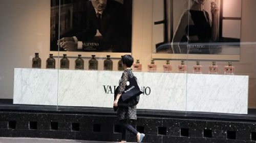 一名中国游客路过奢侈品牌华伦天奴在巴黎的一家门店。（美联社）