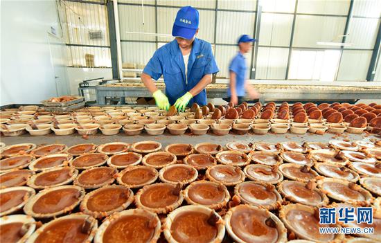 云南省弥勒市竹园镇那俺村竹诚食品厂工人正在忙着制作红糖。新华网发(普佳勇1月2日摄)