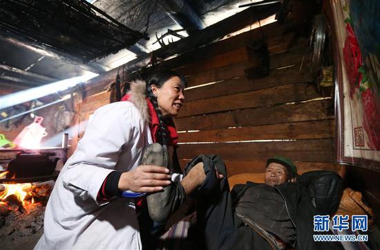 在云南怒江贡山县丙中洛镇,管延萍(左)指导一名村民进行康复训练(1月13日摄)。