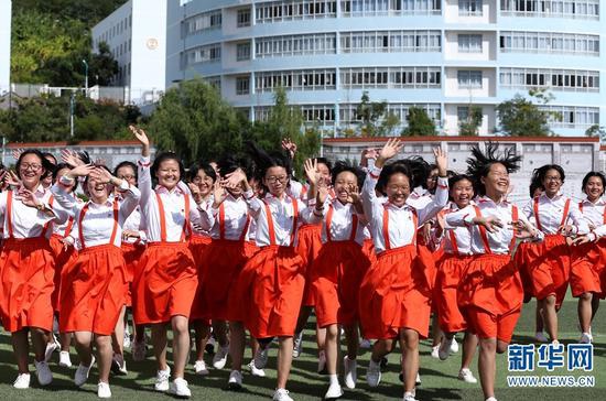 丽江华坪女子高级中学,学生们面对镜头欢快地招手(2019年10月16日摄)。新华网 赵普凡 摄