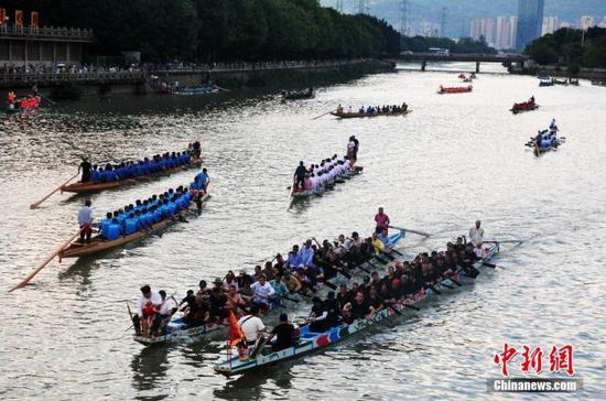 6月13日,福建福州,民众在光明港河道上划龙舟迎端午。 中新社记者 张斌 摄