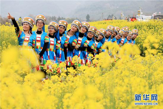 妇女们相约油菜花海欢度节日。新华网发 (李黎 摄)