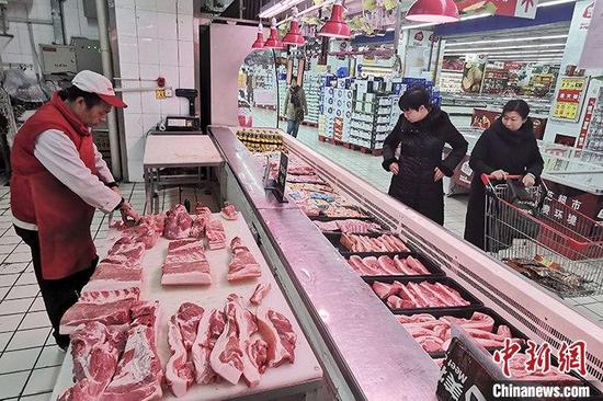 资料图:超市工作人员分解猪肉。中新社记者 张云 摄