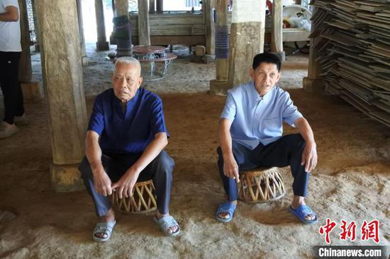 图为83岁曼团村村民波涛岩(左)在曼团联席会议遗址。 中新社记者 罗婕 摄