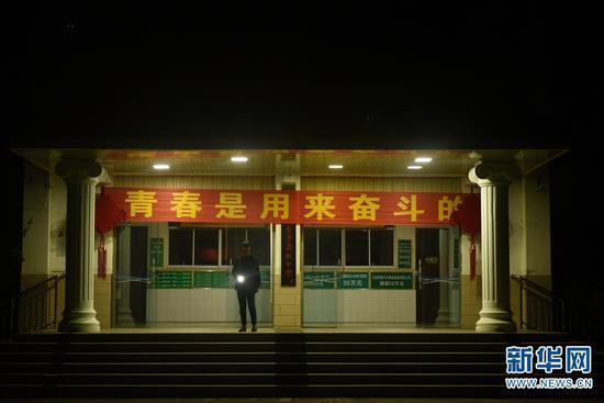 凌晨5点20分左右,张桂梅来到教学楼前,开门、亮灯(2019年10月17日摄)。新华网 李宁 摄