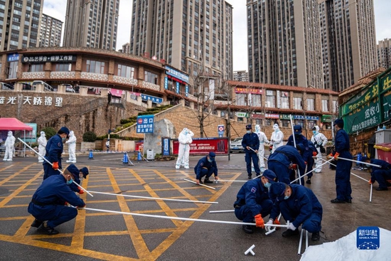 12月26日,在昆明市呈贡区蓝光天娇城小区门口,工作人员在搭建应急帐篷。新华社记者胡超 摄