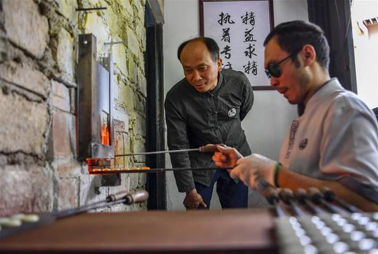 李国伟在云南保山市永子棋厂指导弟子(5月12日摄)。