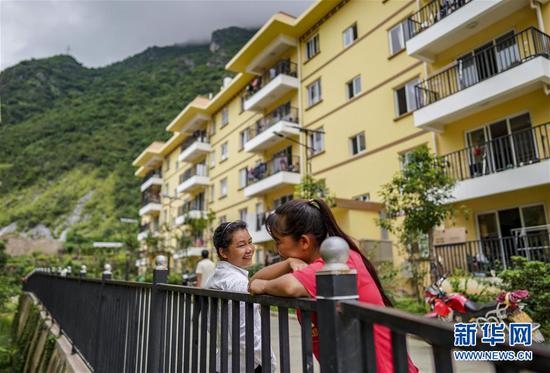 搬迁至怒江傈僳族自治州泸水市大龙塘安置点的居民在家门前聊天(9月15日摄)。新华社记者 江文耀 摄