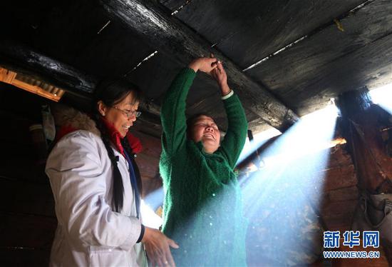 在云南怒江贡山县丙中洛镇,管延萍(左)指导一名村民进行康复训练(1月13日摄)。