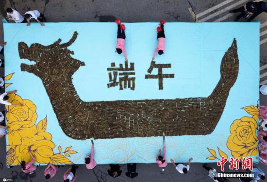 6月13日,中国传统节日端午节前夕,河南洛阳老君山,民众用3000枚槲棕和小米拼成《牡丹龙舟棕》过端午佳节。图片来源:ICphoto