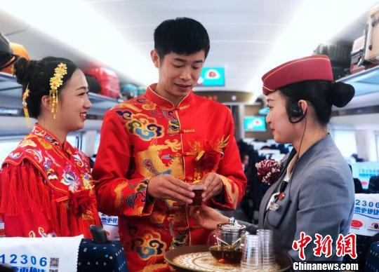 图为动车乘务员为新郎新娘送上祝福的茶水。胡芃 摄