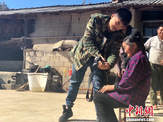 图为杨董清为村民拍摄照片 杨钏杰 摄