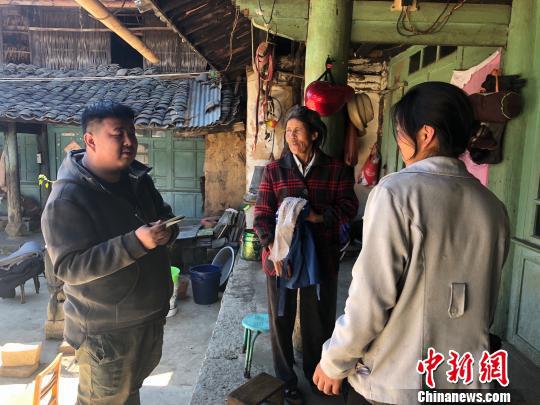 图为拍摄小组成员了解村民家庭情况 杨志禧 摄