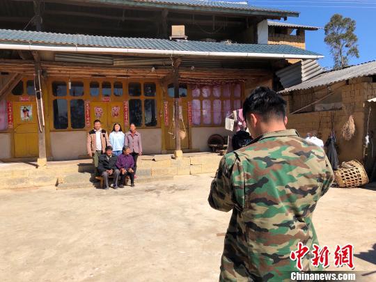 图为杨董清正在为村民拍摄全家福 杨志禧 摄