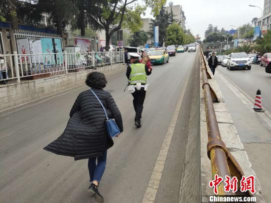 图为交警接过孩子奔向医院。曲靖交警提供