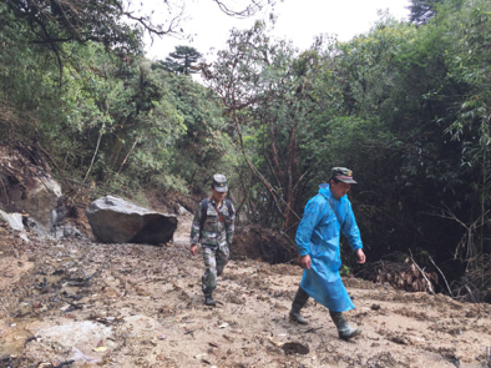 ▲界务员蔡新装(右)和蔡添光在去往“共和国1号碑”的路上。新华每日电讯记者林碧锋摄