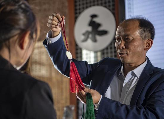 李国伟向顾客推荐利用永子制作的文创产品(5月12日摄)。