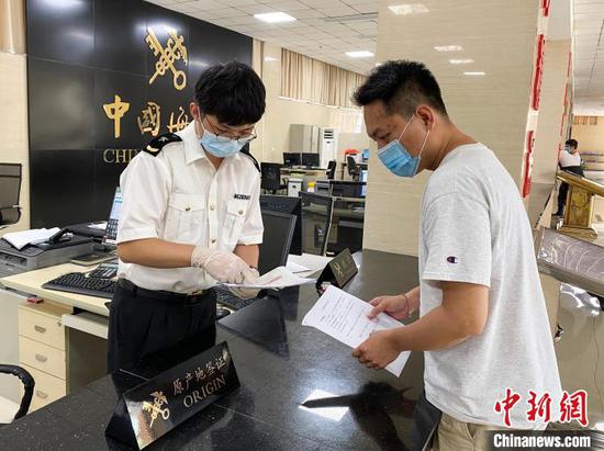 图为海关关员向企业介绍RCEP原产地规则。 窦金锐 摄