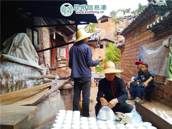 杨斌全(戴草帽站立者)与老伴正在制作诺邓井盐。记者江枫/摄