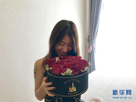 2月14日,在泰国曼谷,一位女士收到由云南鲜花制作成的花盒。 新华社记者 张可任 摄
