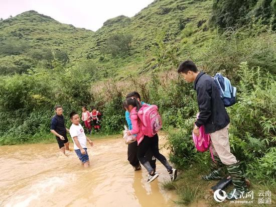 暖心!上学路被淹 云南广南乡村教师趟水背娃上下学