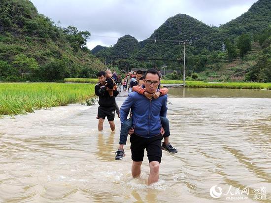 暖心!上学路被淹 云南广南乡村教师趟水背娃上下学