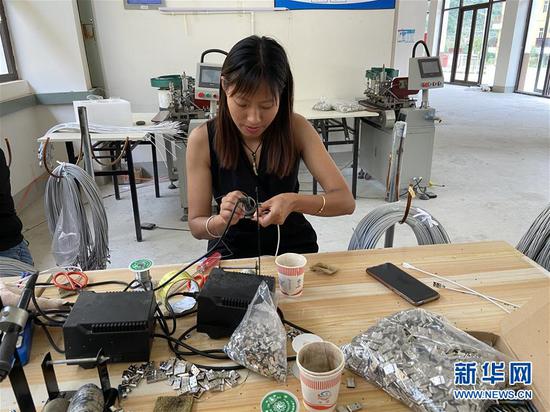 密珍花在云南怒江傈僳族自治州泸水市大兴地镇维拉坝珠海社区数据线加工扶贫车间工作(6月1日摄)。新华社发