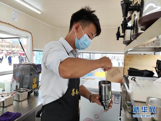 云南昭通靖安新区的搬迁农民王仕坤在制作奶茶(8月8日摄)。 新华社记者 林碧锋 摄
