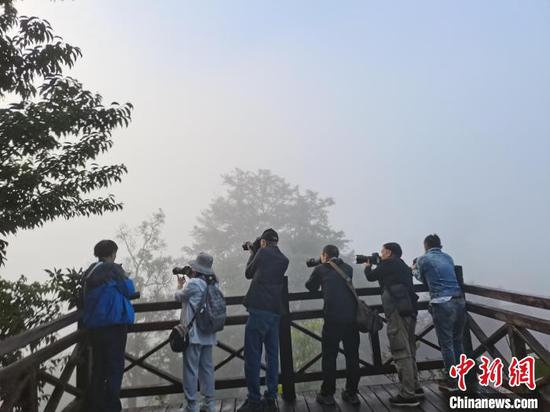 图为摄影家正在进行拍摄。 中国民俗摄影协会供图