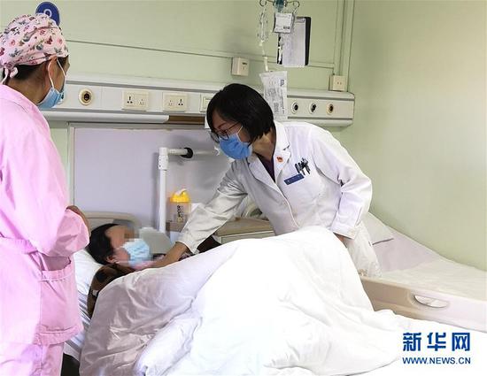 11月20日,北京地坛医院妇产科主任李丽为感染HIV的孕妇检查。 新华社发