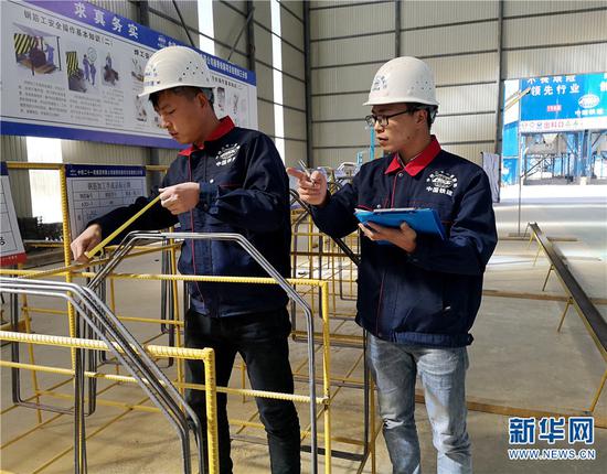 中铁二十一局集团路桥公司技术人员测量钢件。