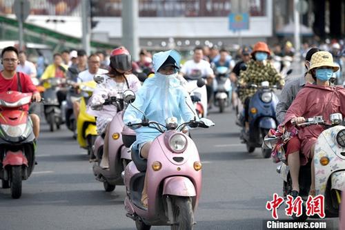 资料图:6月17日,广西南宁高温持续,市民“全副武装”遮阳出行。中新社记者 俞靖 摄
