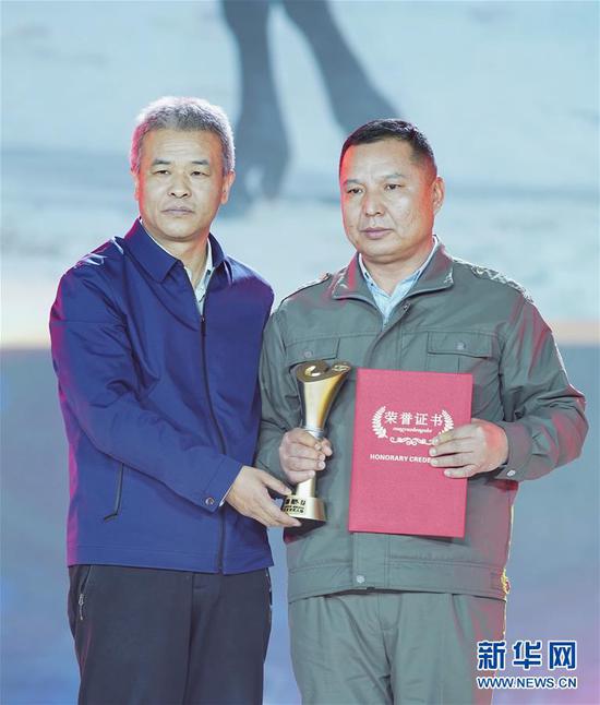 1月16日,“胡杨林守护者”艾力·尼亚孜(右)在颁奖典礼上。新华社记者 才扬 摄