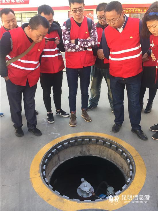 加油站工作人员向市民讲解加油站装卸环节过程中采取的安全措施和先进设施设备。