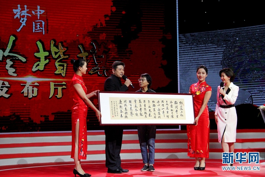 “云岭楷模”专场发布会现场,工作人员向张桂梅赠予书法作品(摄于6月29日)。(新华网 念新洪 摄)