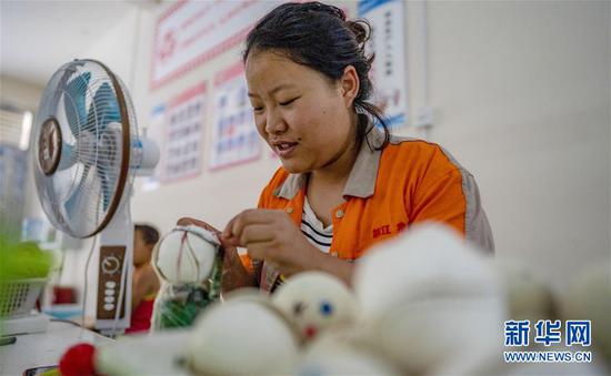 在云南怒江傈僳族自治州福贡县托坪易地扶贫搬迁集中安置点,28岁的花六妹在村里的棒球缝制车间当质检员(9月17日摄)。新华社记者 江文耀 摄