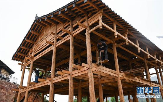 4月7日,板江村村民李天安家在修建具有壮族特色的干栏式建筑。新华社记者 江宏景摄