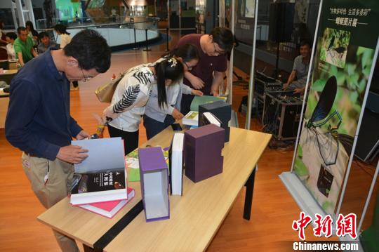图为市民翻阅《中国蜻蜓大图鉴》。 中科院昆明动物研究所供图 摄